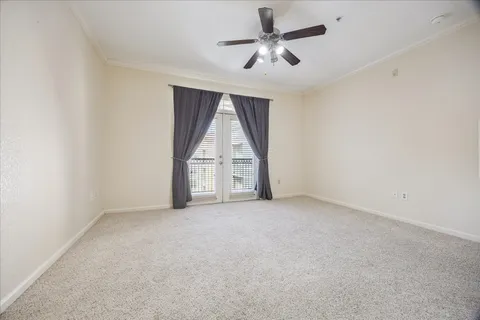 an empty room with a ceiling fan and windows