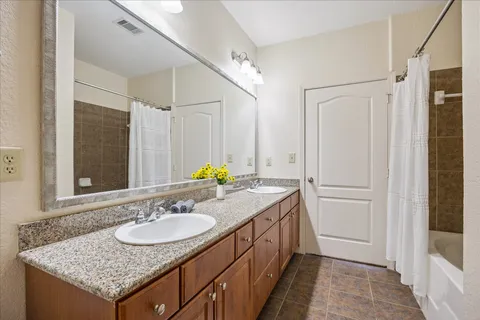 a bathroom with a granite countertop sink and a mirror