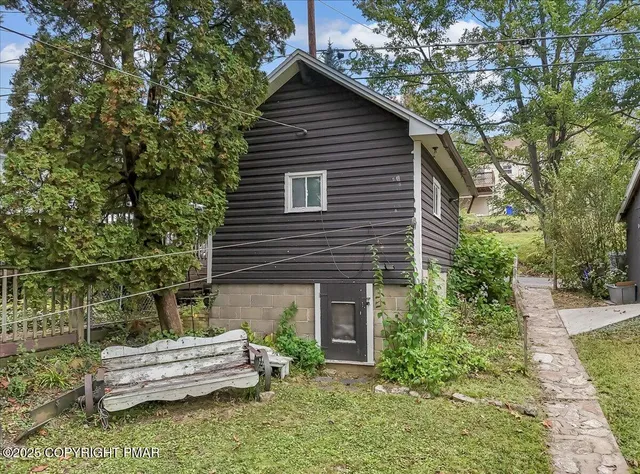 a wooden bench sitting in front of a house