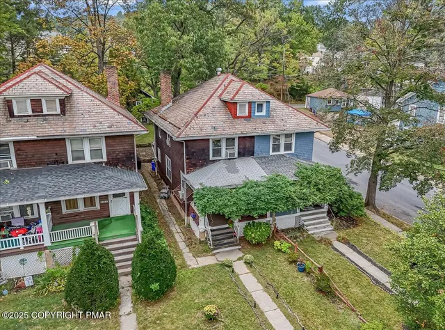 a aerial view of a house with a yard potted plants and a table and chair