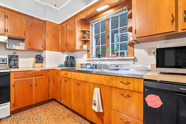 a kitchen with stainless steel appliances granite countertop wooden cabinets a stove a sink and a microwave