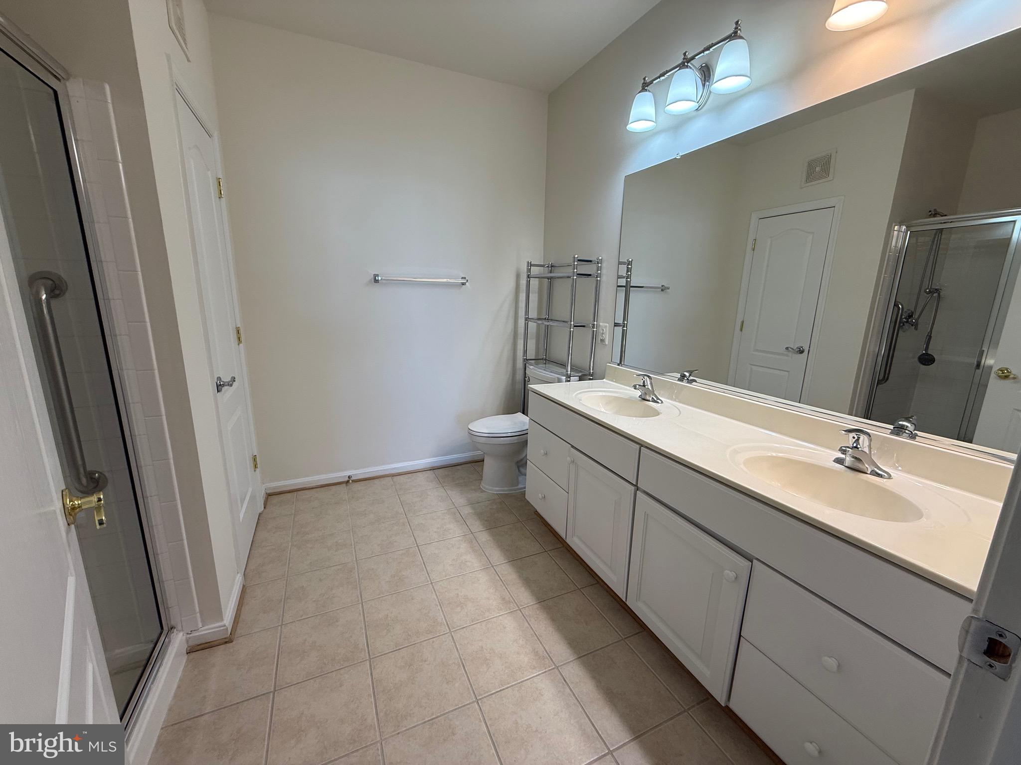 8615 Wandering Fox Trail, Unit 208 Odenton, MD 21113 - Photo 16 of 28 a bathroom with a double vanity sink and mirror