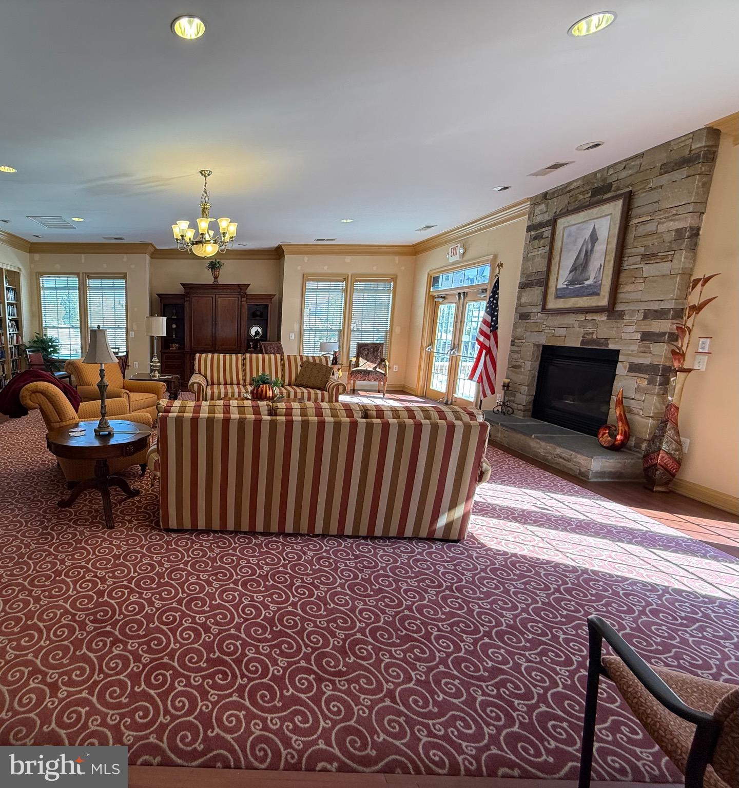 8615 Wandering Fox Trail, Unit 208 Odenton, MD 21113 - Photo 23 of 28 a living room with furniture a fireplace and a chandelier