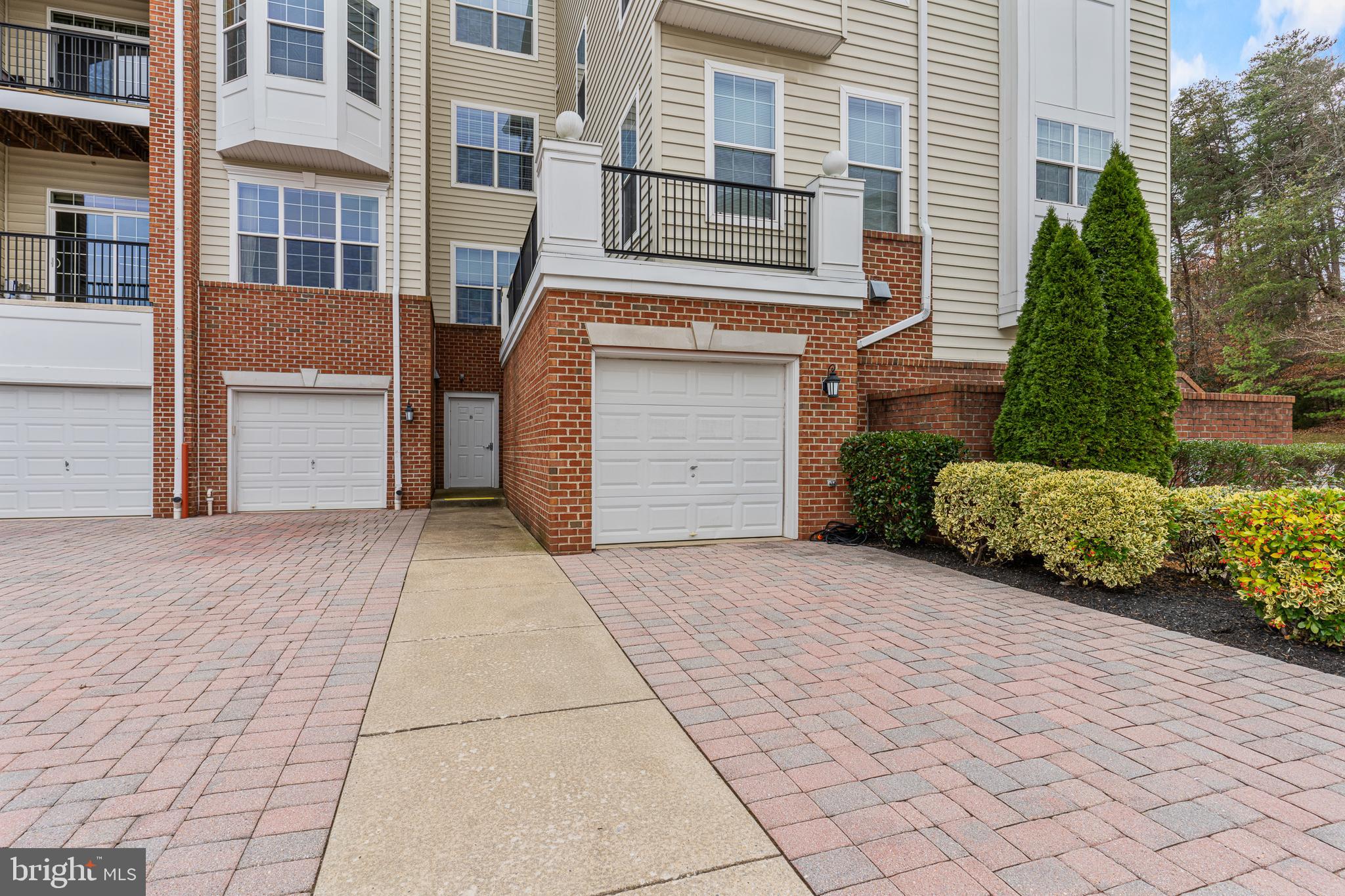 8615 Wandering Fox Trail, Unit 208 Odenton, MD 21113 - Photo 3 of 28 a front view of a house with a yard and garage