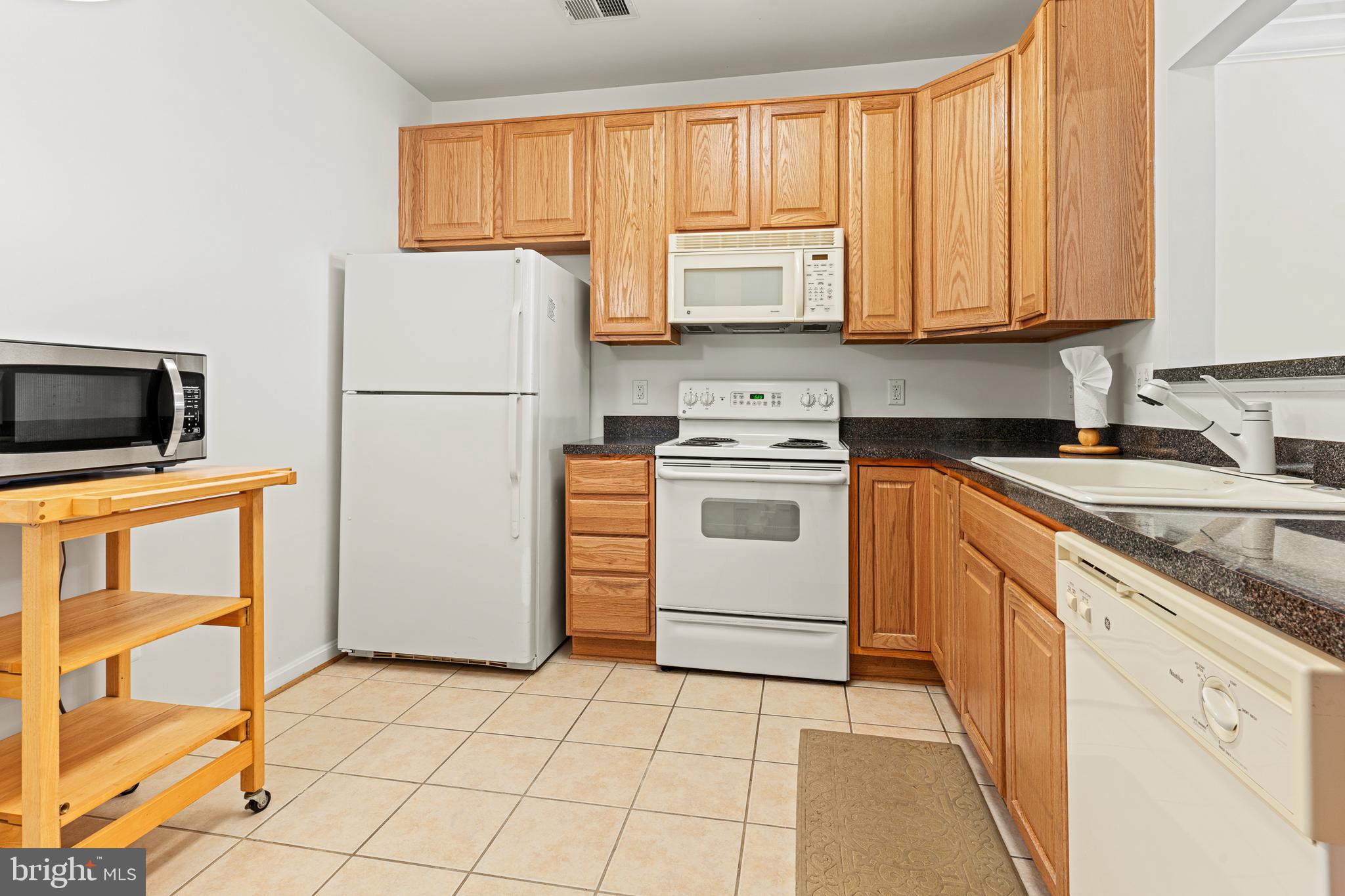 8615 Wandering Fox Trail, Unit 208 Odenton, MD 21113 - Photo 5 of 19 a kitchen with a stove a sink and a refrigerator