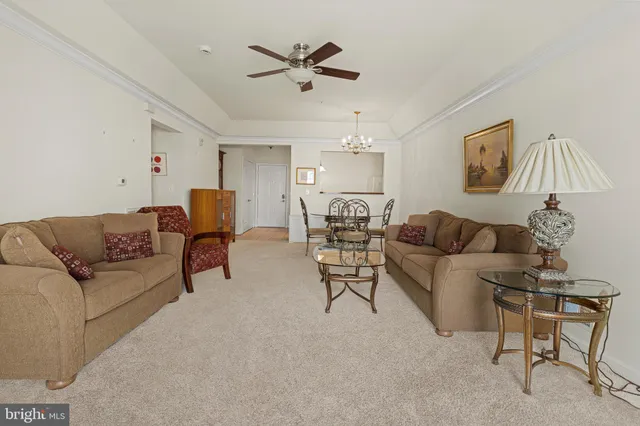a living room with furniture and a ceiling fan