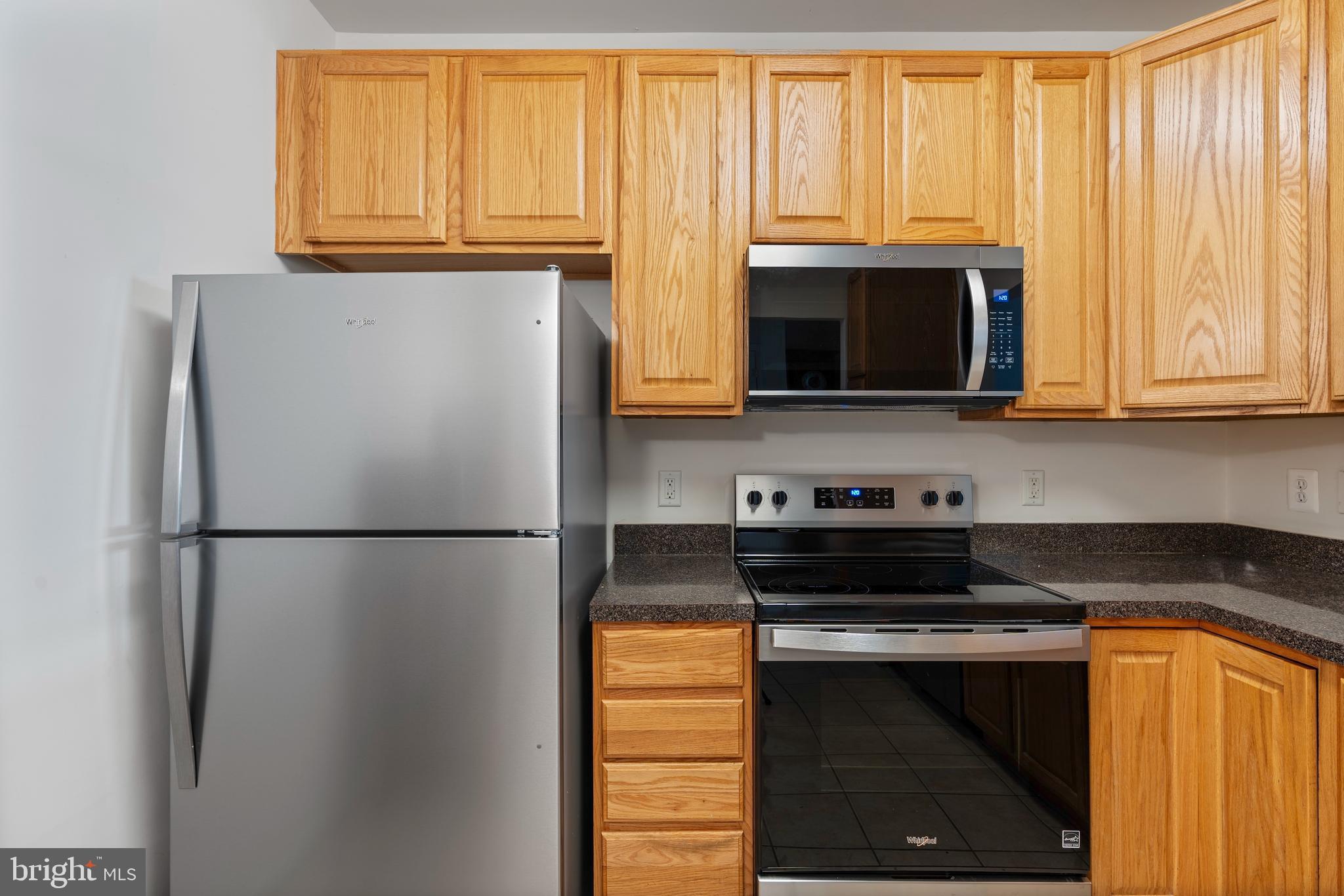 8615 Wandering Fox Trail, Unit 208 Odenton, MD 21113 - Photo 9 of 28 a white refrigerator freezer sitting in a kitchen