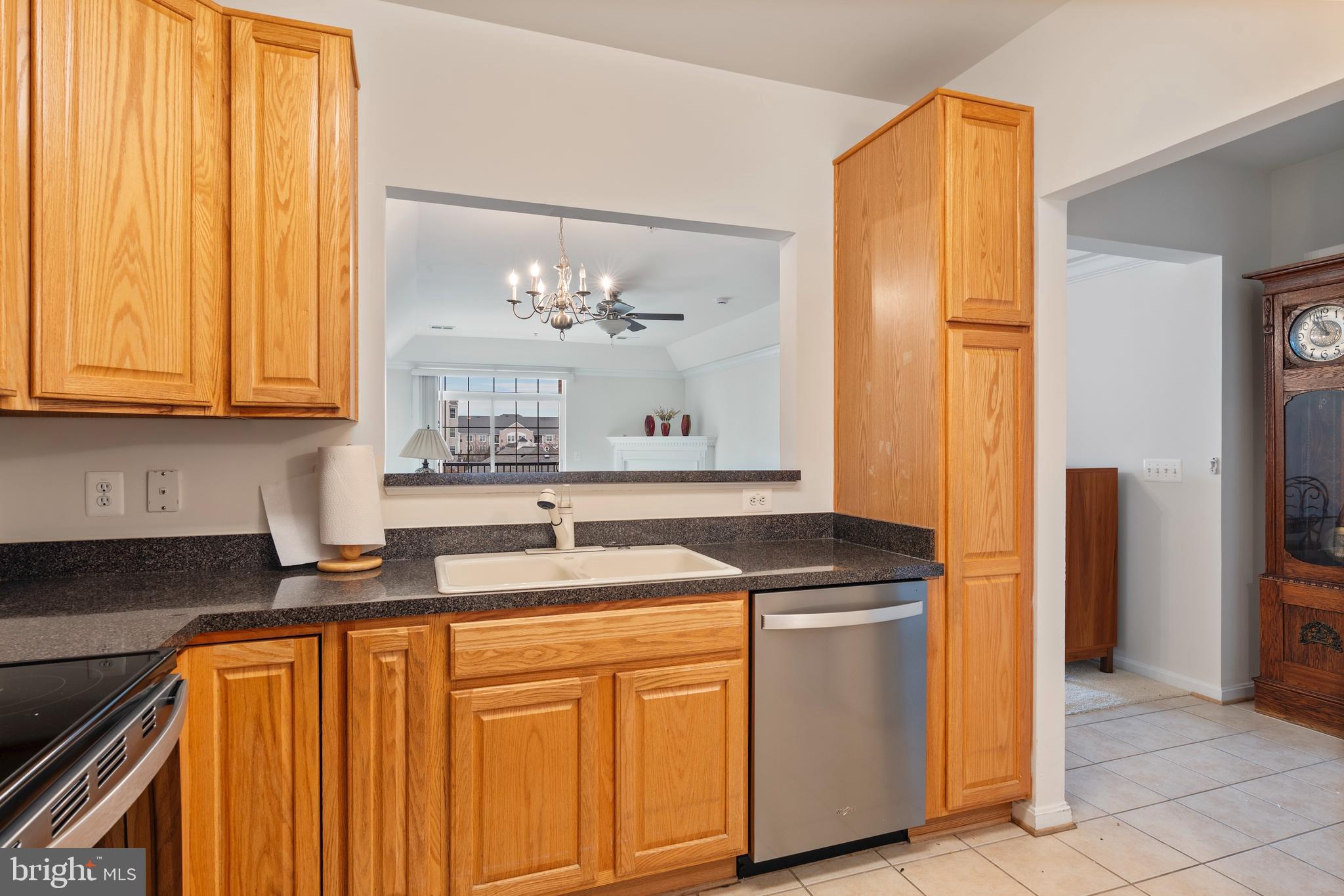 8615 Wandering Fox Trail, Unit 208 Odenton, MD 21113 - Photo 9 of 22 a kitchen with stainless steel appliances granite countertop a refrigerator a sink dishwasher and white cabinets with wooden floor