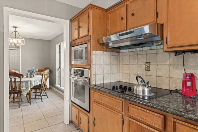 a kitchen with stainless steel appliances granite countertop a sink a stove and cabinets