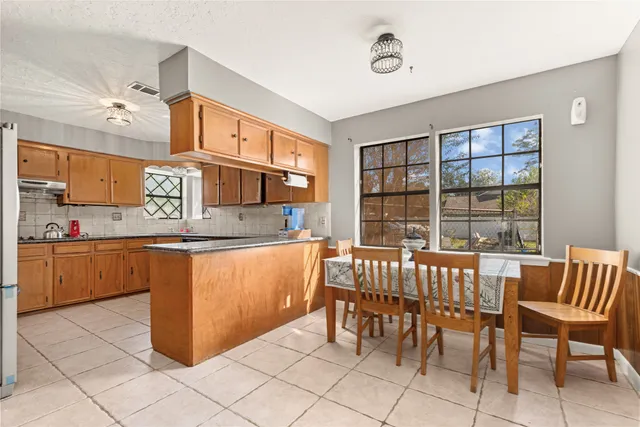 a kitchen with stainless steel appliances granite countertop a sink and a refrigerator