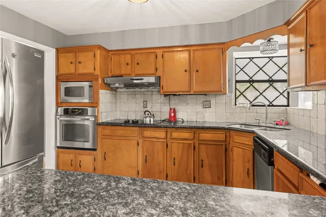 a kitchen with stainless steel appliances granite countertop a sink stove and refrigerator