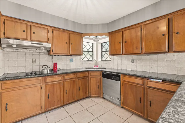a kitchen with cabinets appliances a sink and a window
