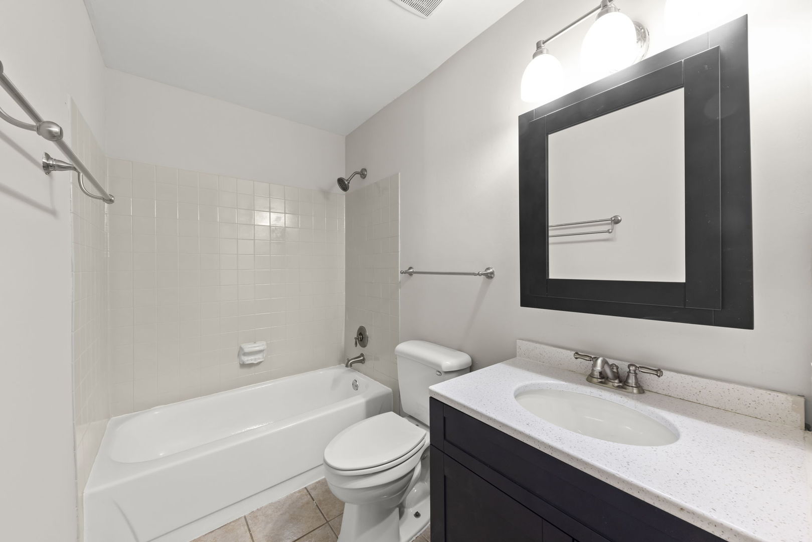 1324 McDowell Road, Unit 104 Naperville, IL 60563 - Photo 12 of 20 a bathroom with a sink vanity mirror bathtub and toilet