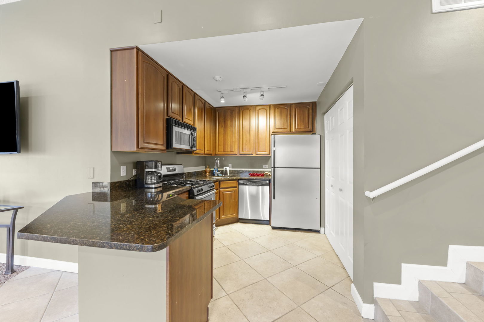 1324 McDowell Road, Unit 104 Naperville, IL 60563 - Photo 16 of 20 a kitchen with stainless steel appliances granite countertop a refrigerator a stove a sink and a microwave