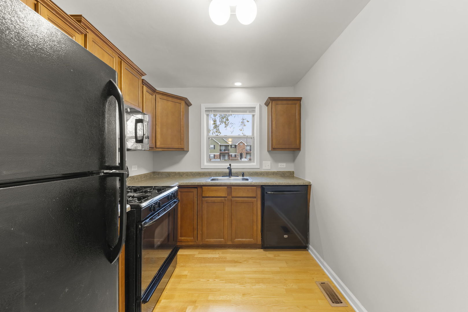 1324 McDowell Road, Unit 104 Naperville, IL 60563 - Photo 6 of 20 a kitchen with stainless steel appliances granite countertop a sink stove and refrigerator