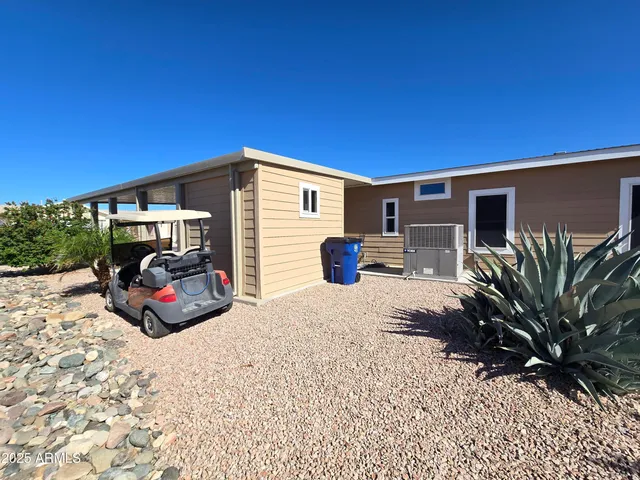 a large kitchen with stainless steel appliances kitchen island granite countertop a refrigerator a sink dishwasher a stove and a dining table with wooden floor