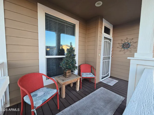 a view of a patio with chairs and wooden floor