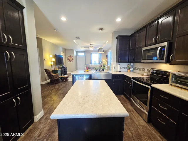 a view of living room and kitchen with granite countertop lots of clutter