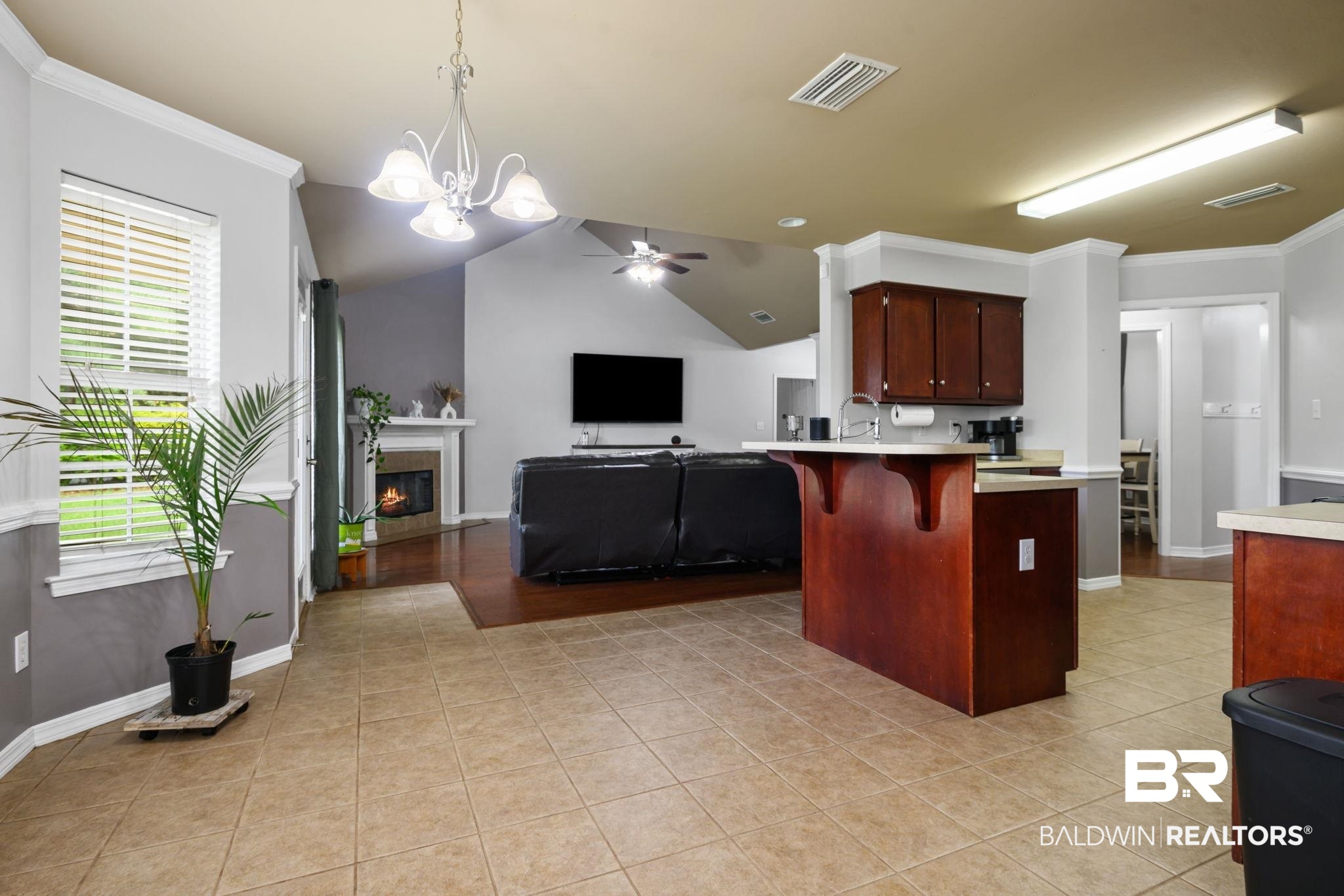 9422 Labrador Run South Mobile, AL 36695 - Photo 14 of 36 Open-concept interior featuring light tile flooring and a kitchen island with dark wood-finish cabinetry