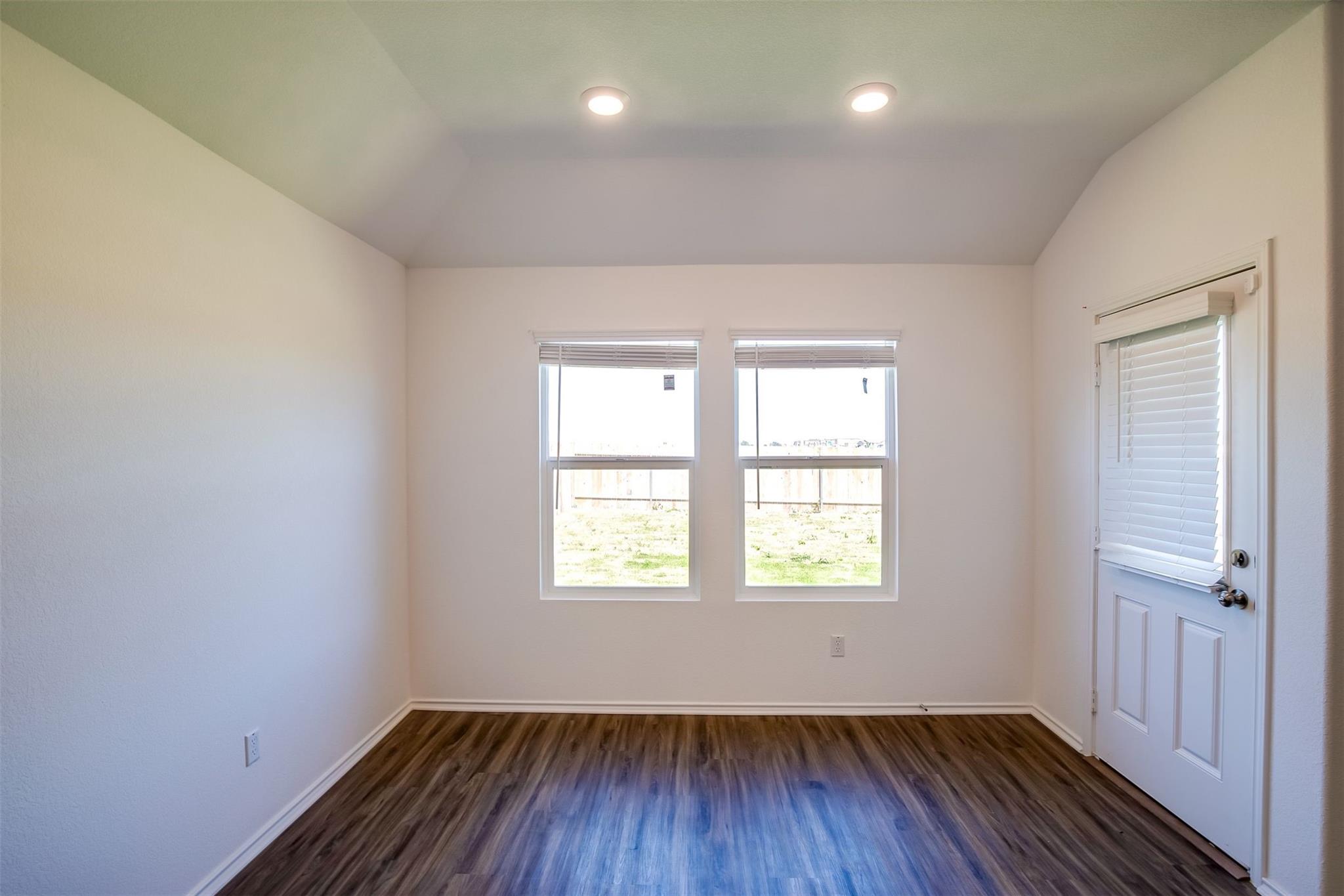614 Milliner Loop Hutto, TX 78634 - Photo 18 of 25 A well-lit room features durable wood flooring and ample natural light from multiple windows.
