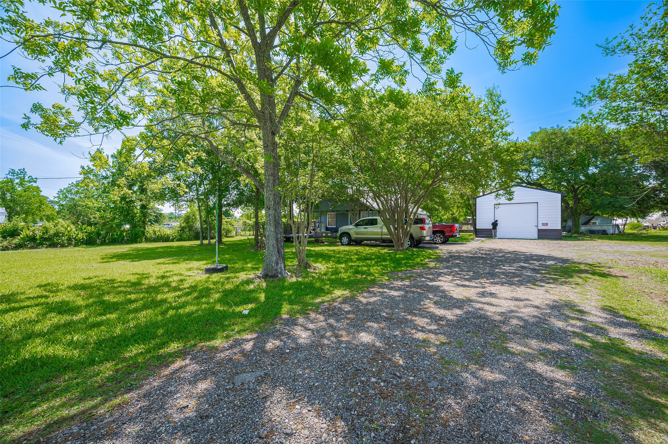 A path runs through open grassy stretches, lined by trees that offer both shade and serenity. The sheer scale of the property becomes evident here.