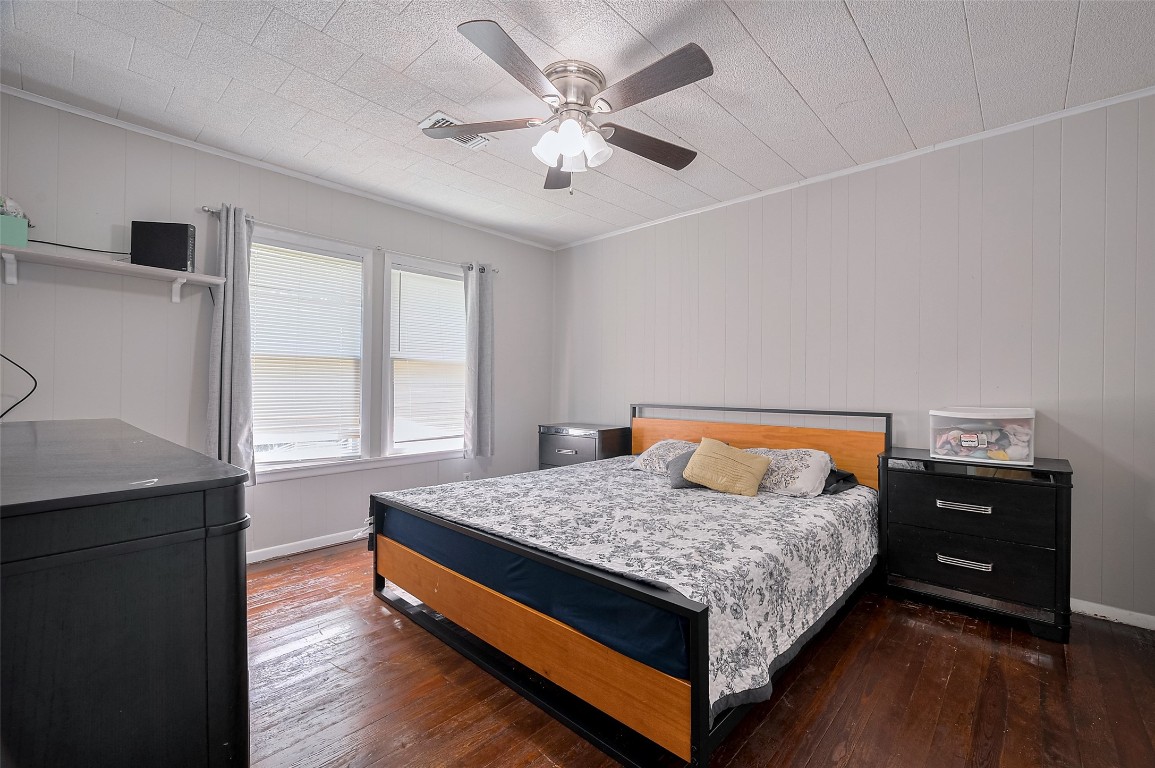 16128 1/2 Ridlon Street Channelview, TX 77530 - Photo 17 of 43 The primary bedroom offers peaceful retreat vibes with wood floors, a large window, and a ceiling fan overhead to keep the space cool.