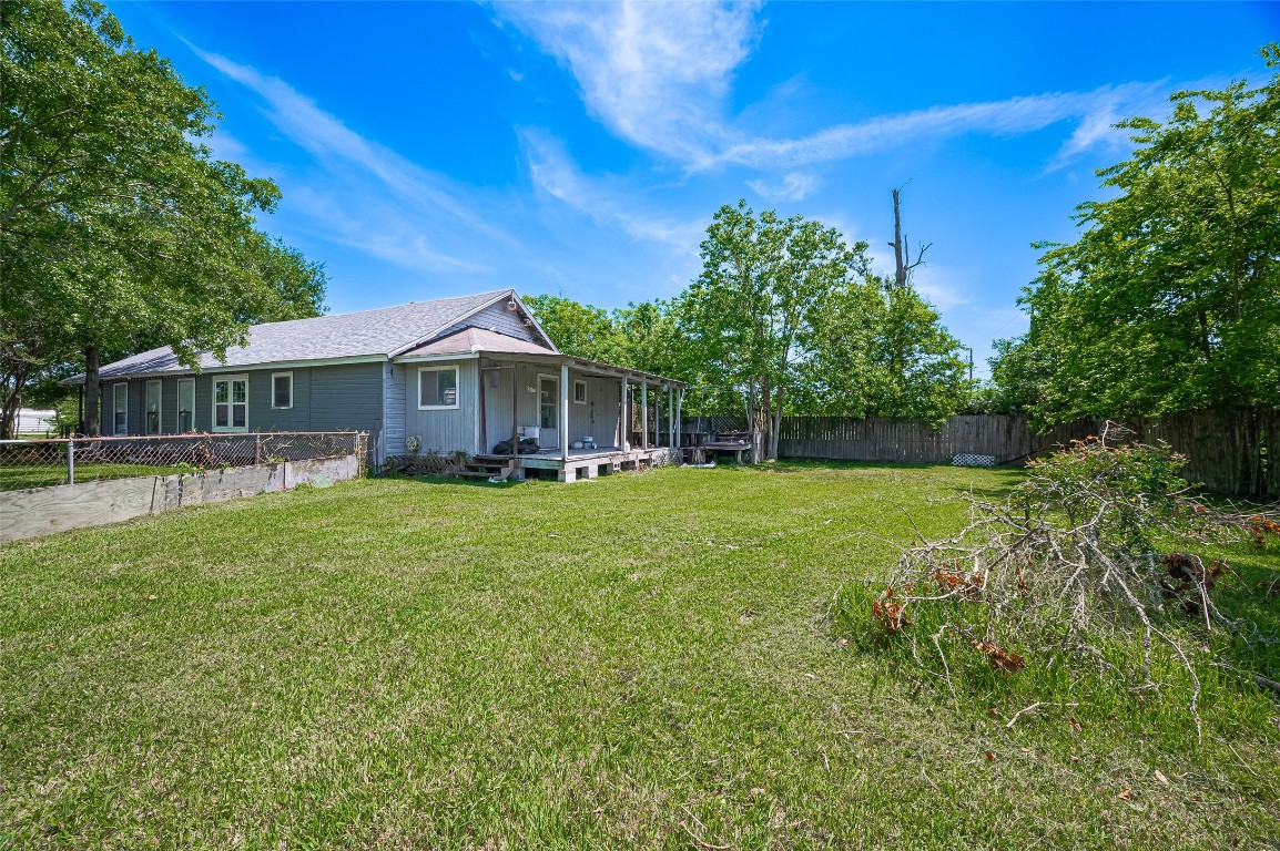 16128 1/2 Ridlon Street Channelview, TX 77530 - Photo 5 of 43 Around back, the elevated rear porch offers a quiet perch overlooking the expansive yard—your own private green escape with endless space.