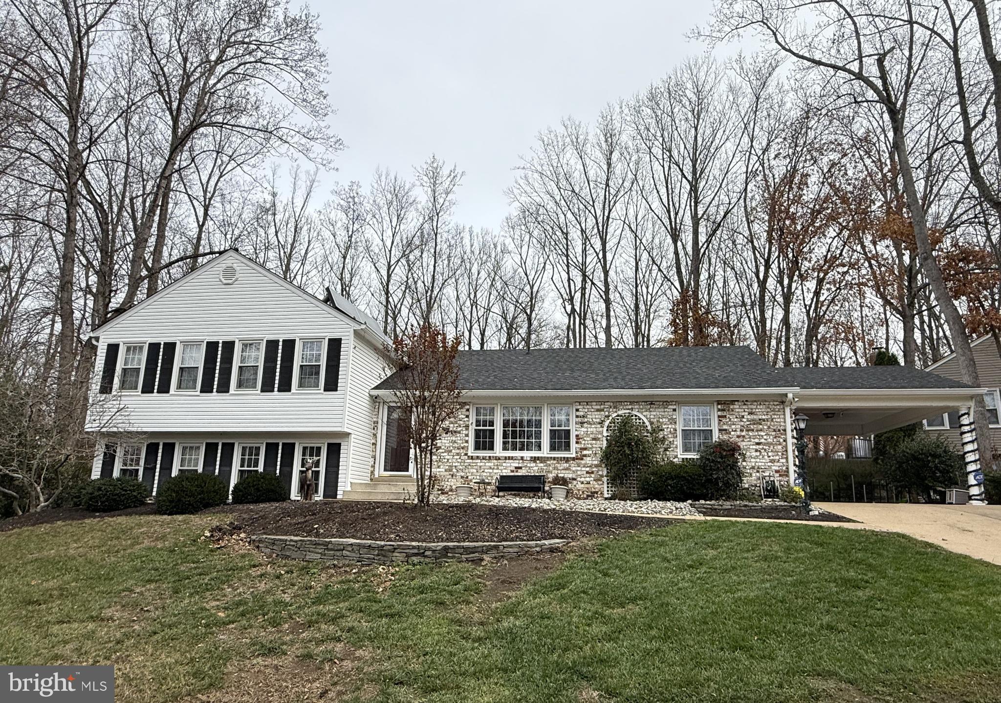12001 Skipjack Court Lake Ridge, VA 22192 - Photo 1 of 2 a front view of a house with a garden