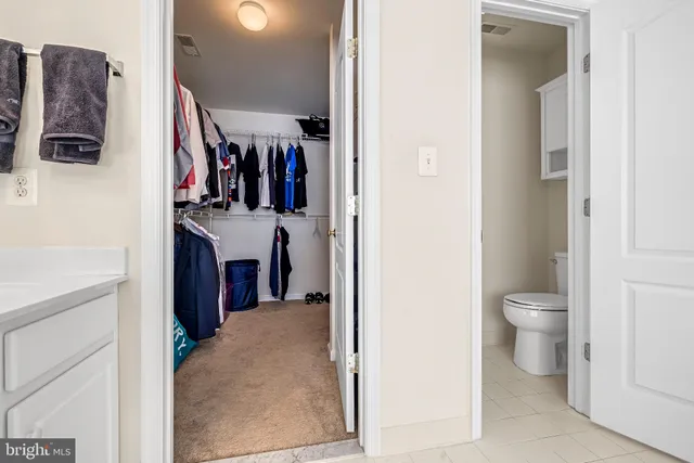 a view of a hallway with a livingroom and a bathroom