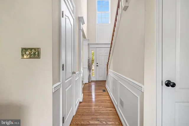 a view of a hallway with wooden floor and staircase