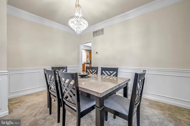 a view of a dining room with furniture and chandelier