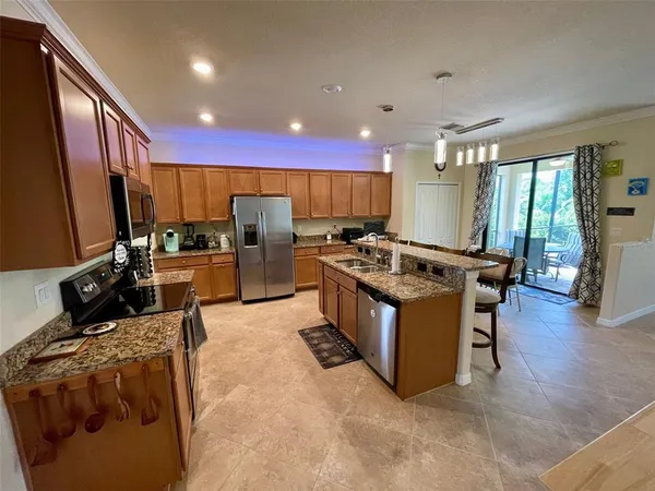 a kitchen with stainless steel appliances kitchen island granite countertop a stove and a sink