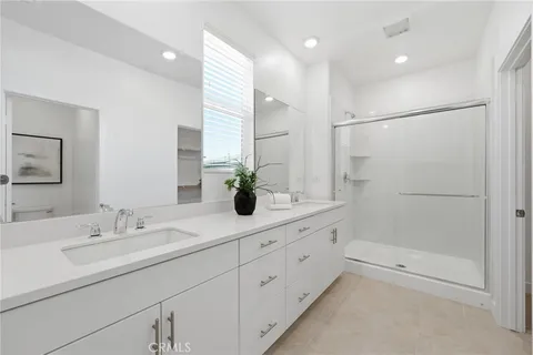 a bathroom with a shower sink and mirror