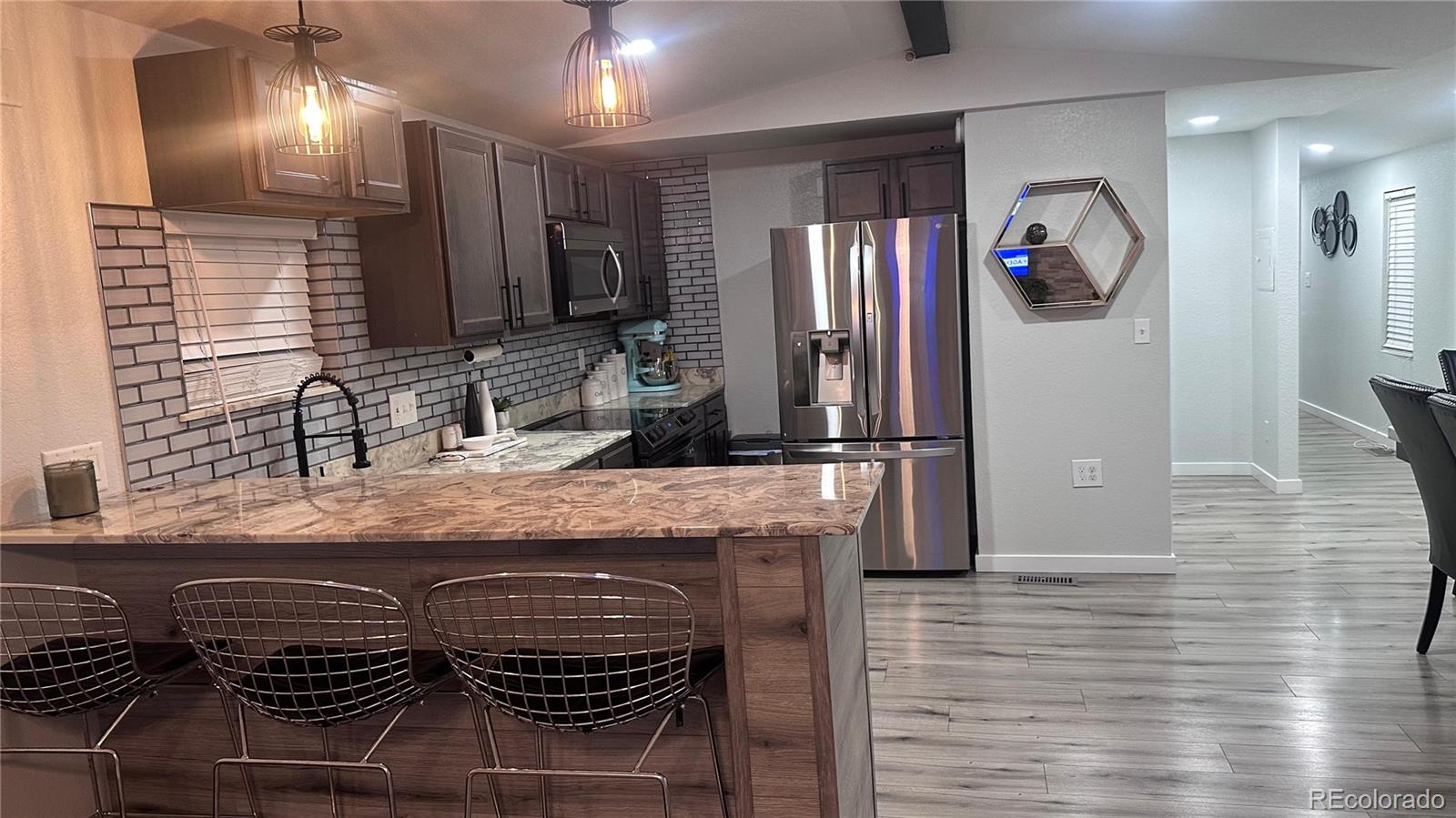 2612 Swale Run Colorado Springs, CO 80916 - Photo 14 of 25 a kitchen with granite countertop a refrigerator and a sink