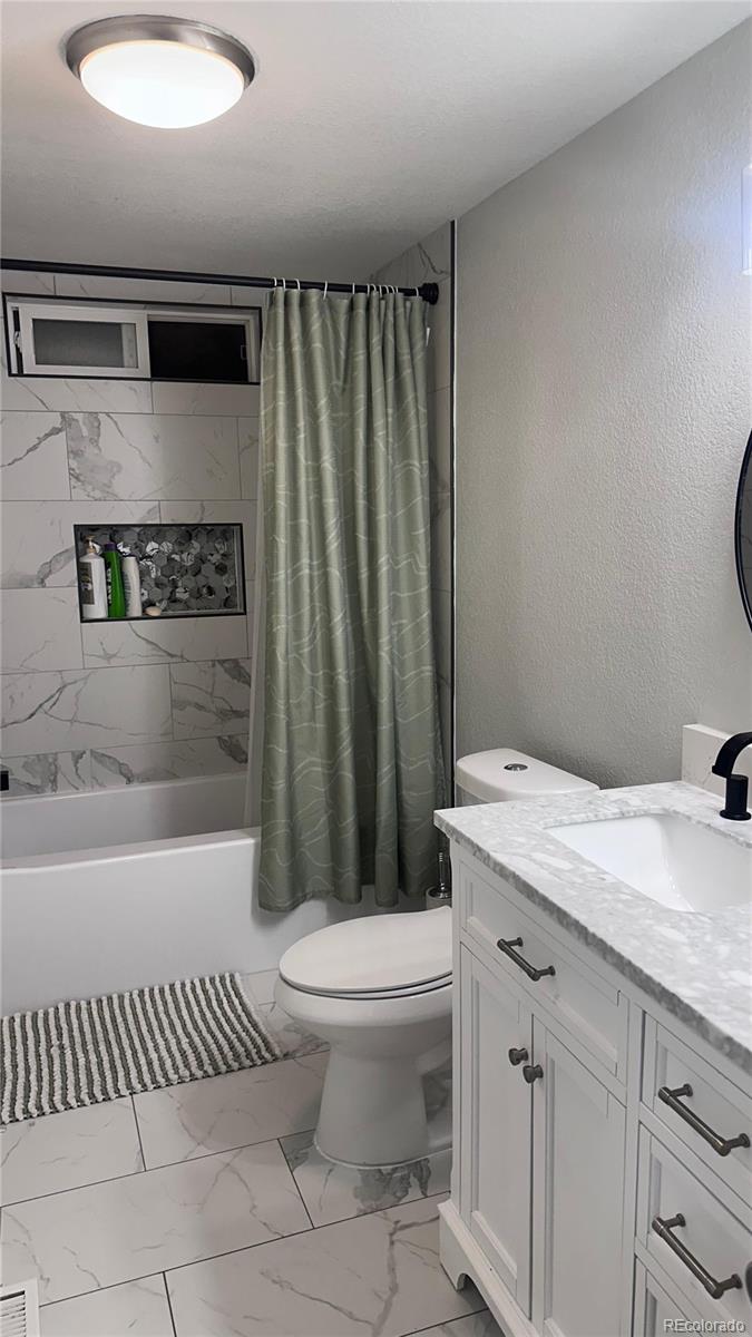 2612 Swale Run Colorado Springs, CO 80916 - Photo 18 of 25 a bathroom with a granite countertop bathtub sink vanity mirror and toilet