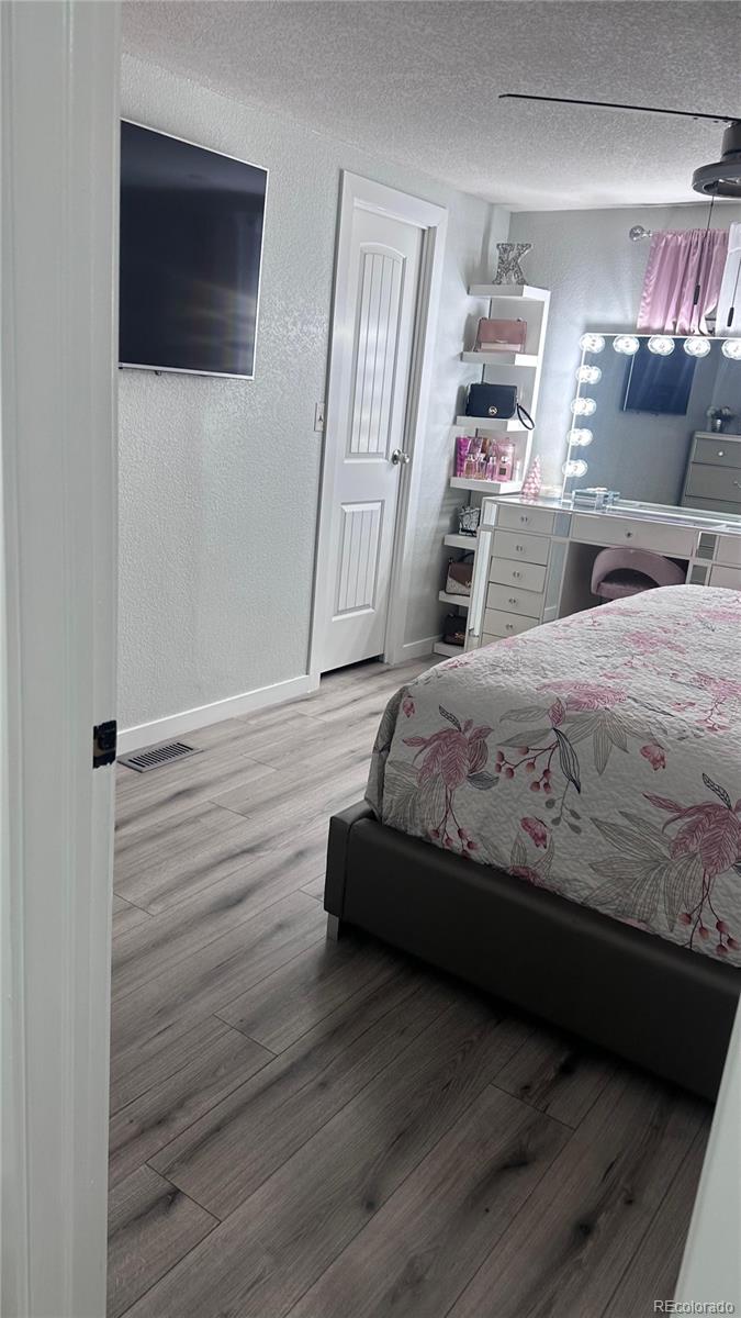 2612 Swale Run Colorado Springs, CO 80916 - Photo 21 of 25 a bedroom with a bed and a flat screen tv