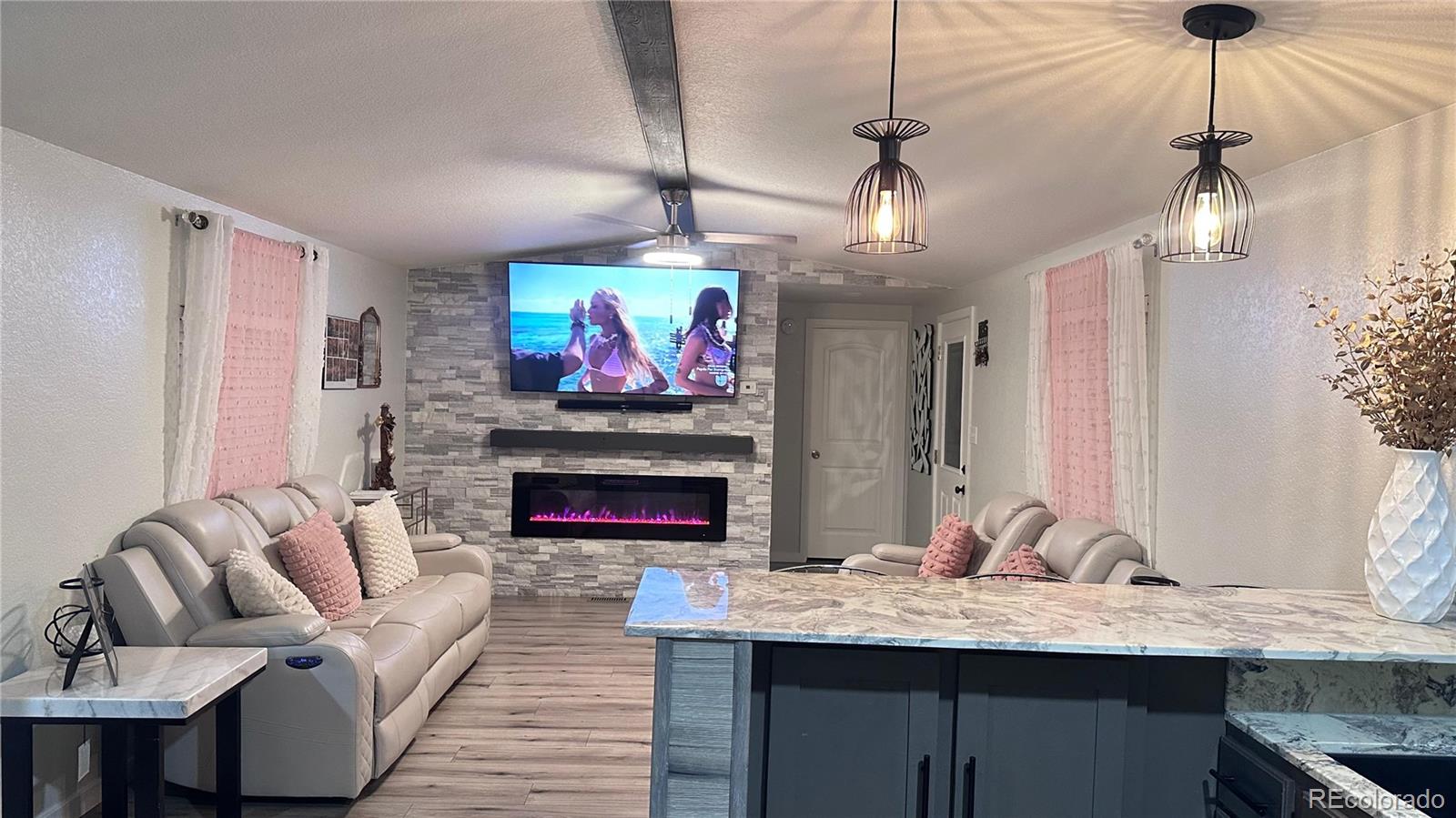 2612 Swale Run Colorado Springs, CO 80916 - Photo 23 of 25 a living room with furniture fireplace and flat screen tv