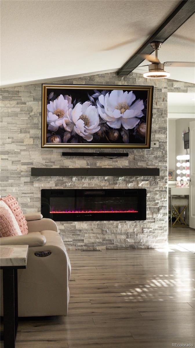 2612 Swale Run Colorado Springs, CO 80916 - Photo 24 of 25 a living room with a fireplace and a flat screen tv