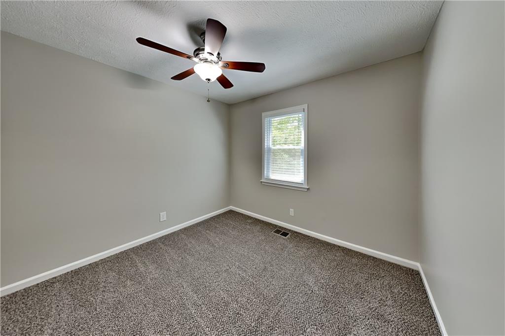 10610 Colony Glen Drive Alpharetta, GA 30022 - Photo 17 of 22 an empty room with a window and a fan