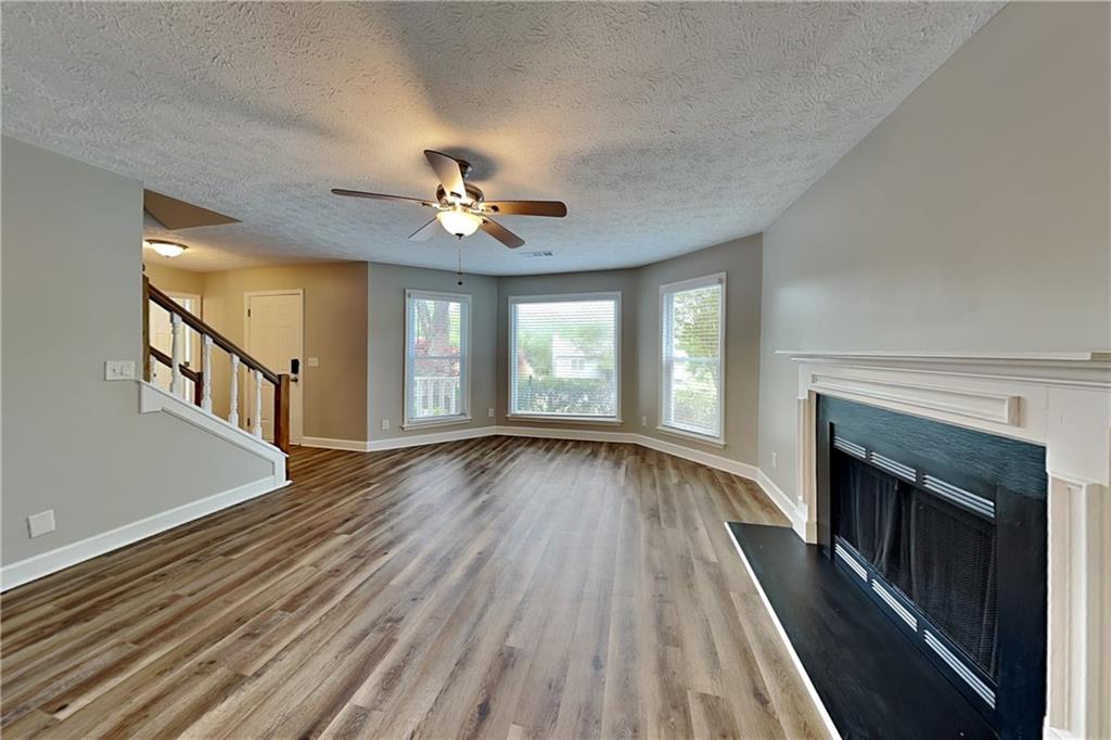 10610 Colony Glen Drive Alpharetta, GA 30022 - Photo 3 of 22 a view of an empty room with wooden floor fireplace and a window