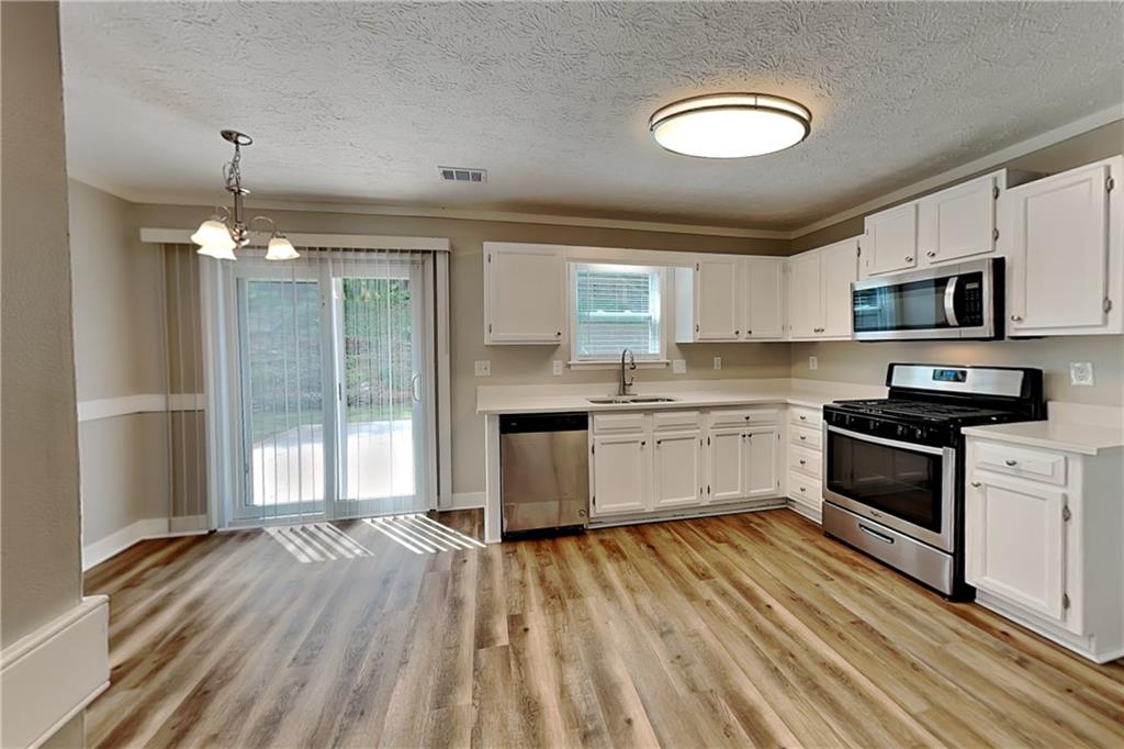 10610 Colony Glen Drive Alpharetta, GA 30022 - Photo 5 of 22 a kitchen with granite countertop a stove cabinets and wooden floor