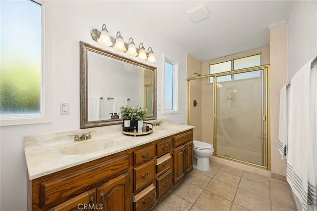 a bathroom with a double vanity sink mirror and shower