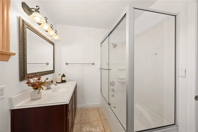a bathroom with a sink mirror and shower