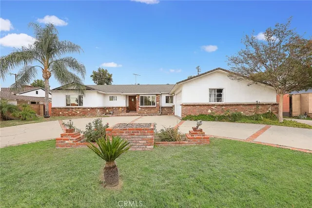a front view of a house with a yard and road