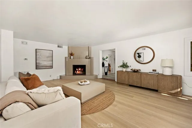 a living room with furniture a clock on wall and a fireplace