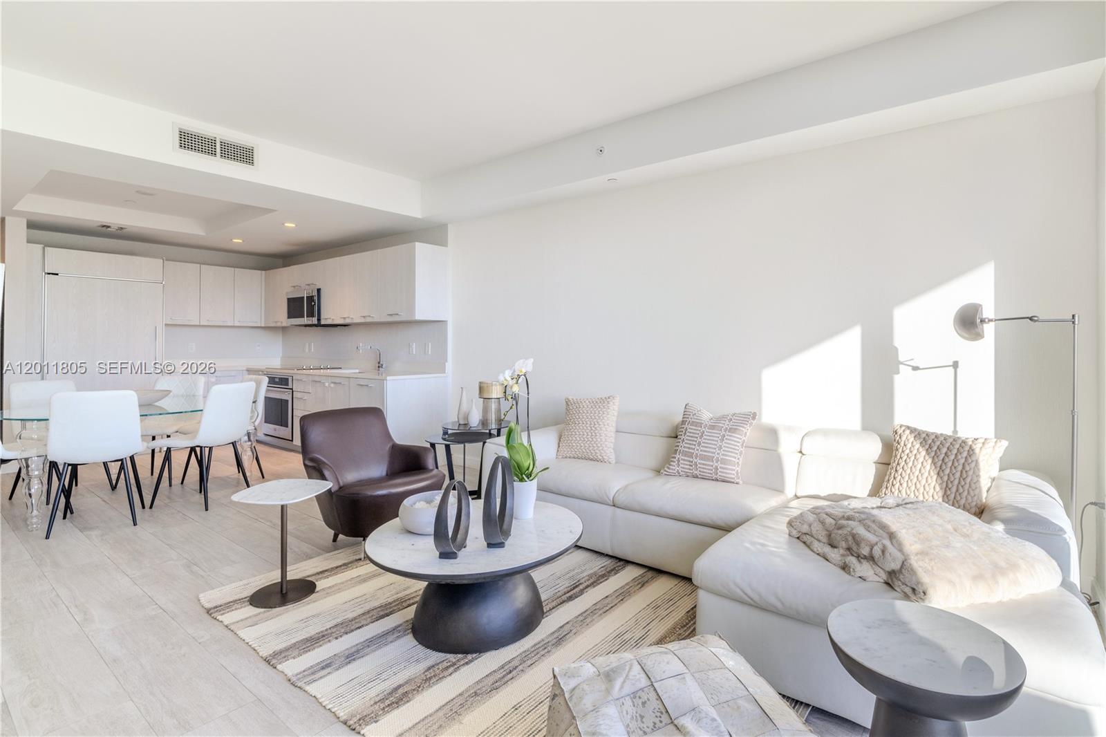 55 Southwest 9th Street, Unit 3404 Miami, FL 33130 - Photo 2 of 25 a living room with furniture and a dining table with kitchen view