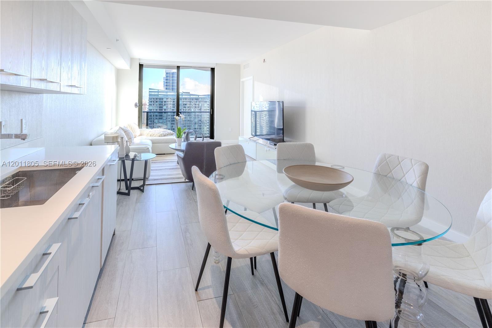 55 Southwest 9th Street, Unit 3404 Miami, FL 33130 - Photo 4 of 25 a dining room with furniture and wooden floor