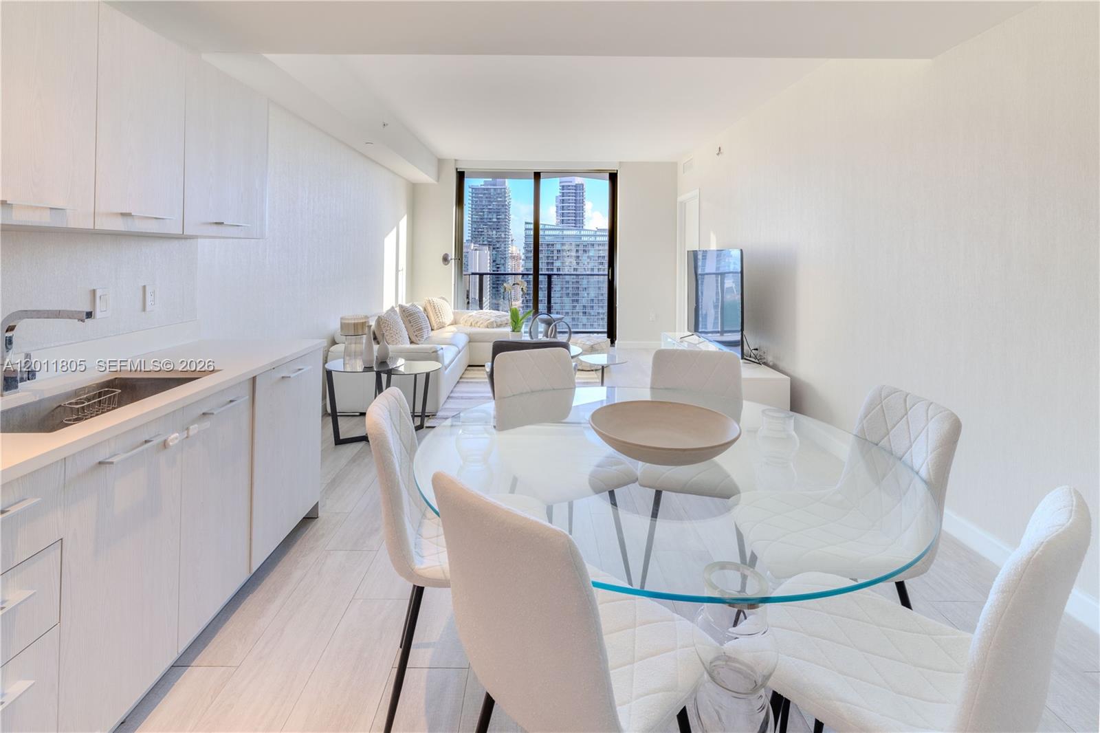 55 Southwest 9th Street, Unit 3404 Miami, FL 33130 - Photo 5 of 25 a kitchen with a table chairs and white cabinets