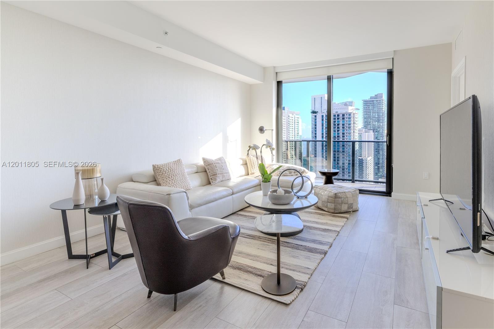55 Southwest 9th Street, Unit 3404 Miami, FL 33130 - Photo 7 of 25 a living room with furniture and a flat screen tv