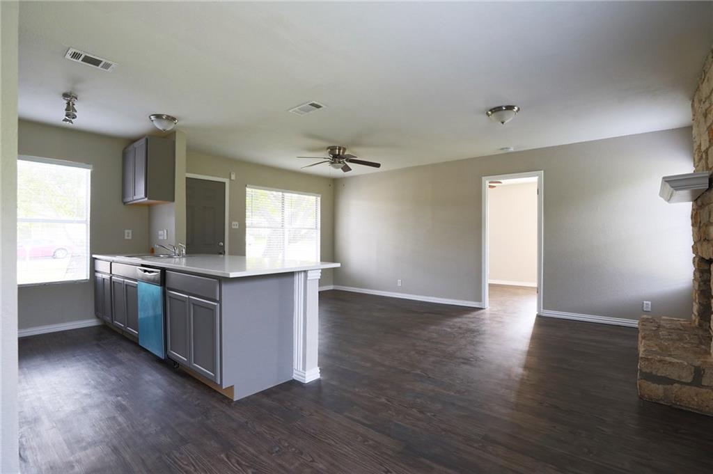 1410 Ransom Street Pflugerville, TX 78660 - Photo 5 of 22 a kitchen with granite countertop a stove and wooden floor